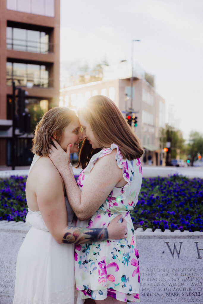 Carley hugging Lauren from behind with soft golden spring light at the Wisconsin State Capitol in Madison, WI.